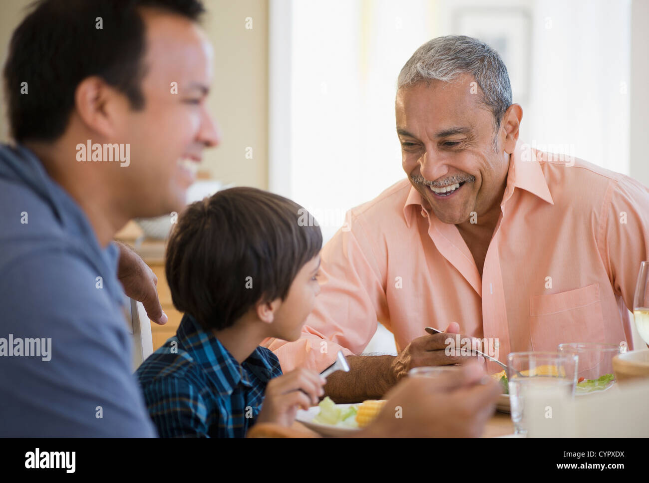 Nonno ispanica, padre e figlio di mangiare la cena Foto Stock
