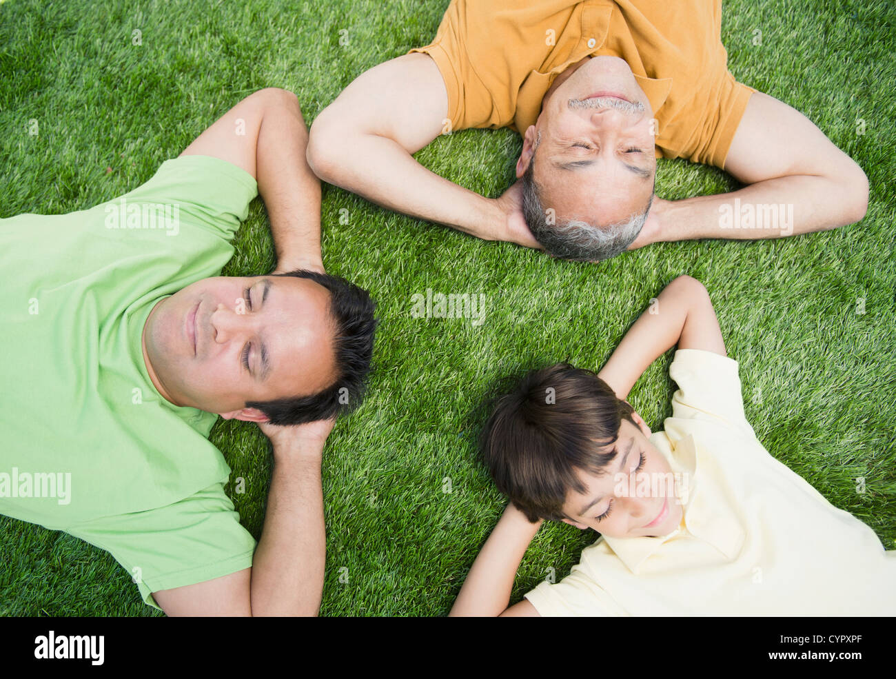 Nonno ispanica, padre e figlio posa in erba Foto Stock
