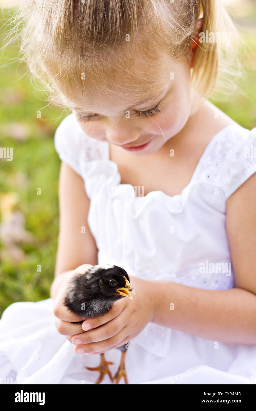 Piccola e dolce ragazza con un po' di pulcino nero per la prima volta. Foto Stock