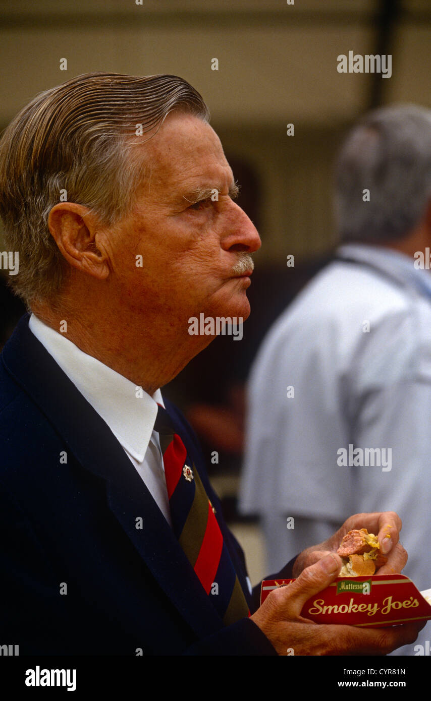 Un gentiluomo inglese di eccellente riproduzione mangia il cibo spazzatura - apparentemente una Mathesons 'Smokey Joe's" hotdog. Foto Stock
