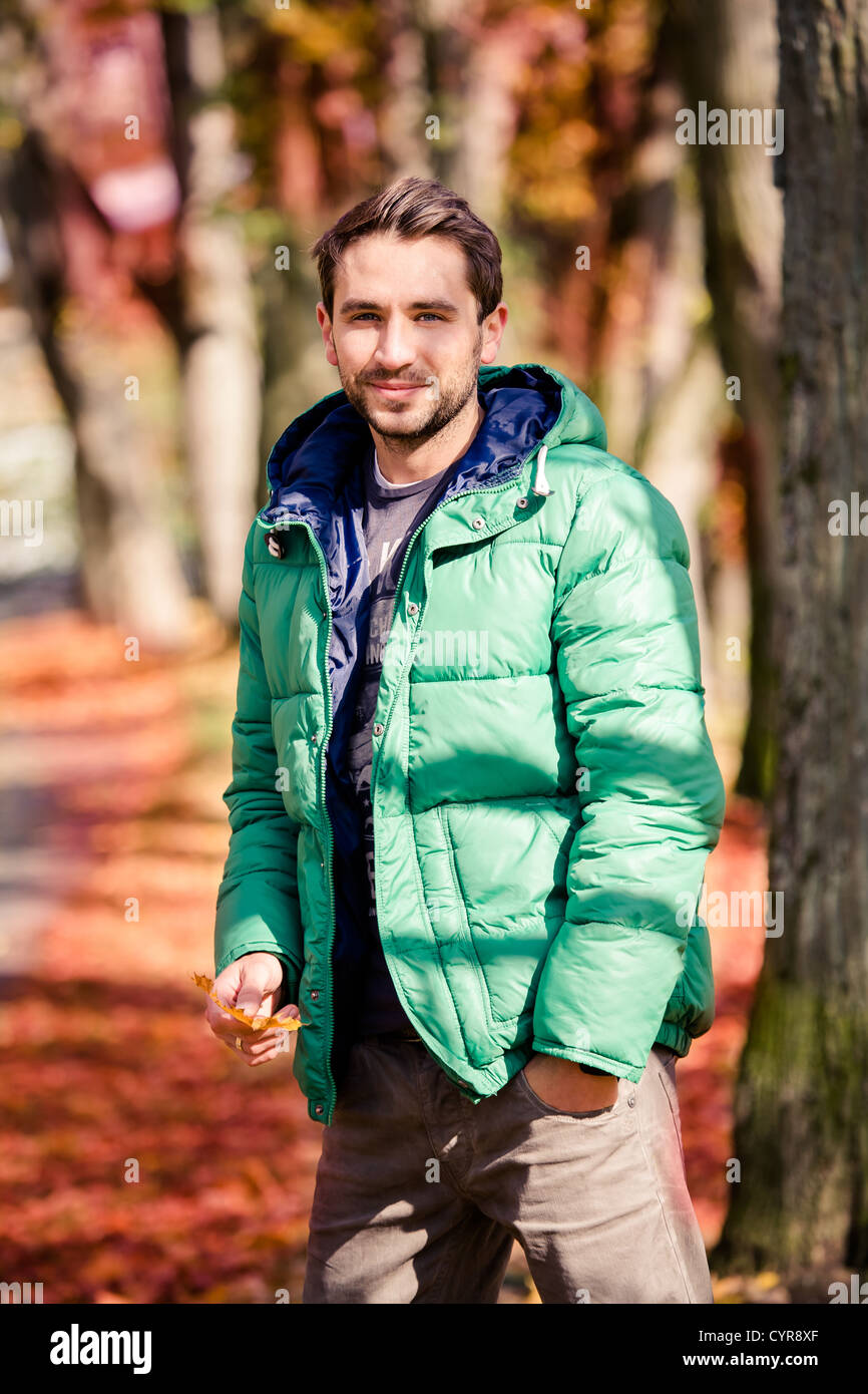 Un giovane uomo nel parco di autunno Foto Stock