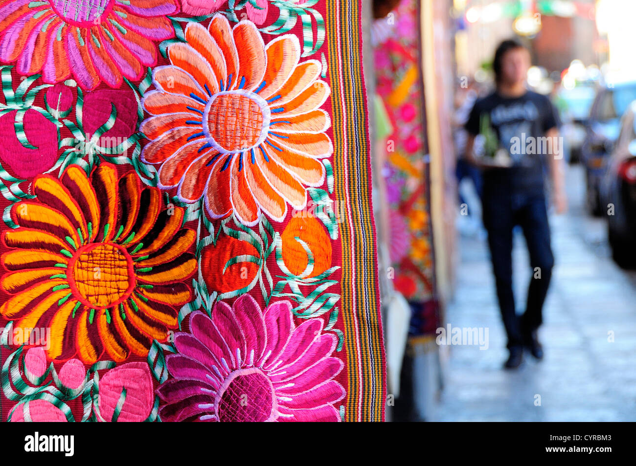 Messico, Bajio, San Miguel De Allende, vivacemente colorato ricamato floreale appeso tessile al di fuori del negozio di arti con design floreale. Foto Stock