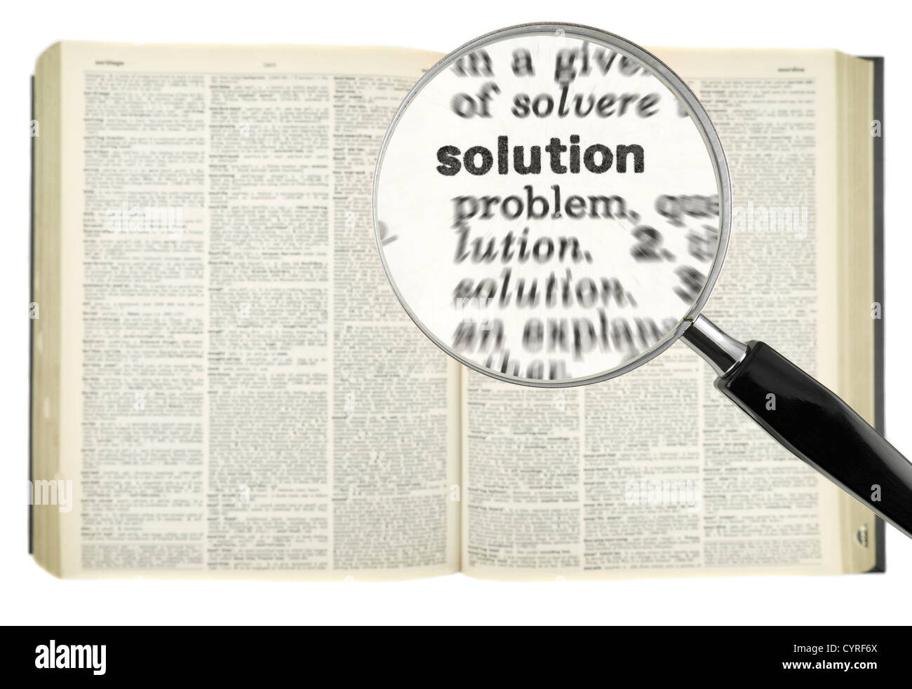 Una lente di ingrandimento sulla soluzione di parola in un dizionario. Foto Stock