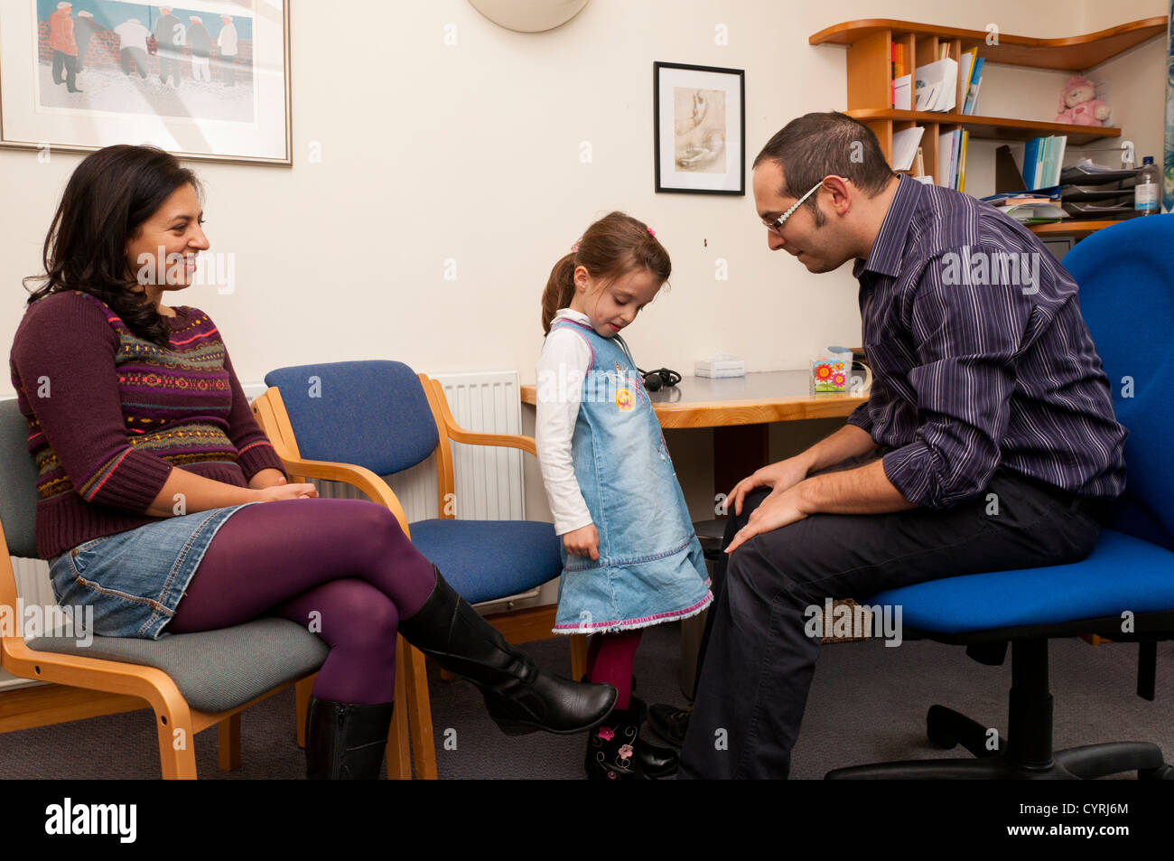 GP ambulatorio medico paziente consultazione con i giovani bambini che ricevono un coraggio adesivo. Foto Stock