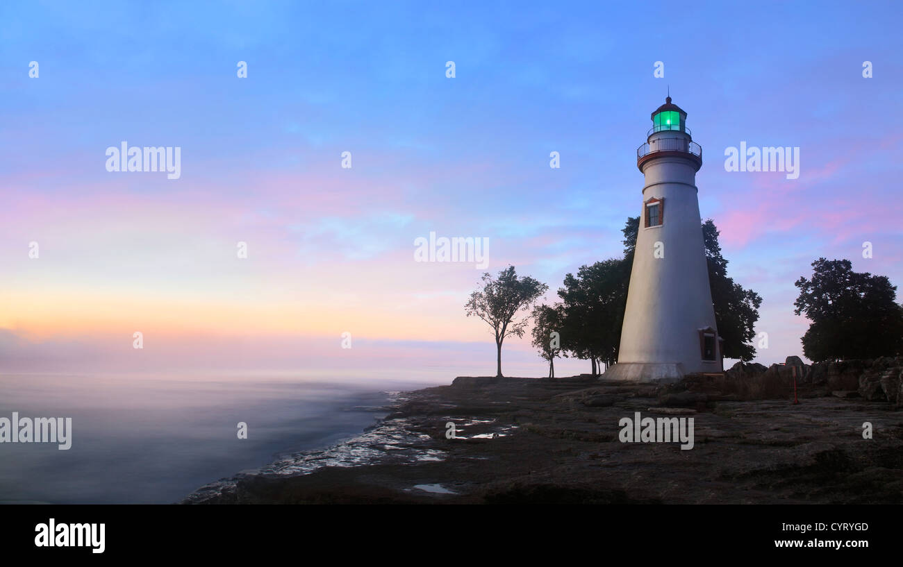 Il Marblehead faro che irradia la luce verde come il sole riscalda il cielo orientale di iniziare una nuova giornata a Marblehead Oh Foto Stock