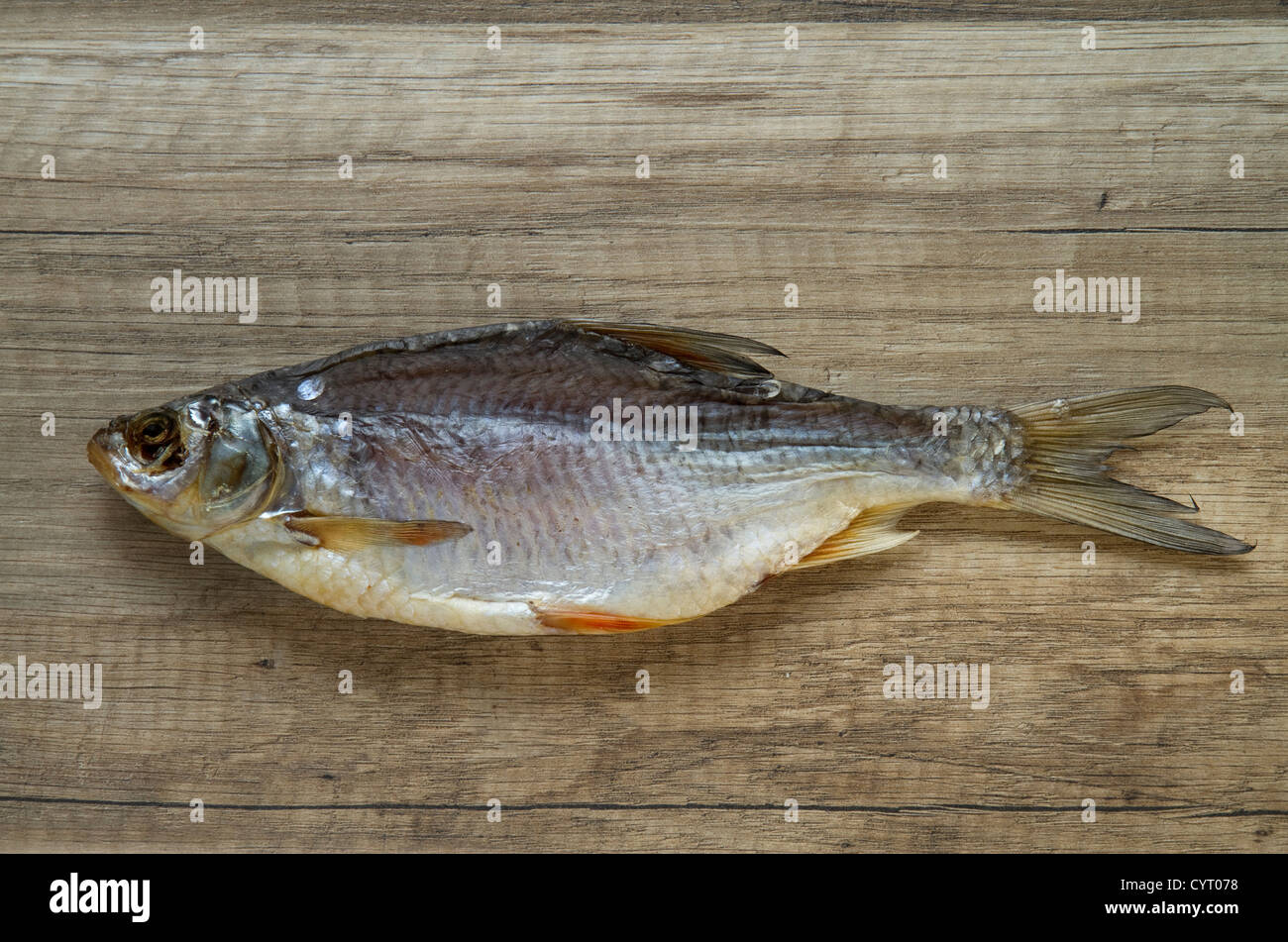 Sale pesce essiccato su sfondo di legno Foto Stock