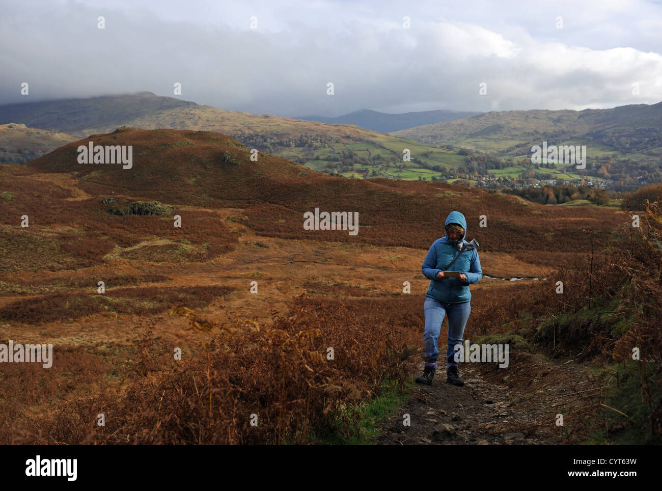 Il panorama intorno a Loughrigg è caduto vicino Ambleside Lake District Woman che si arrampica in cima il giorno d'autunno Foto Stock