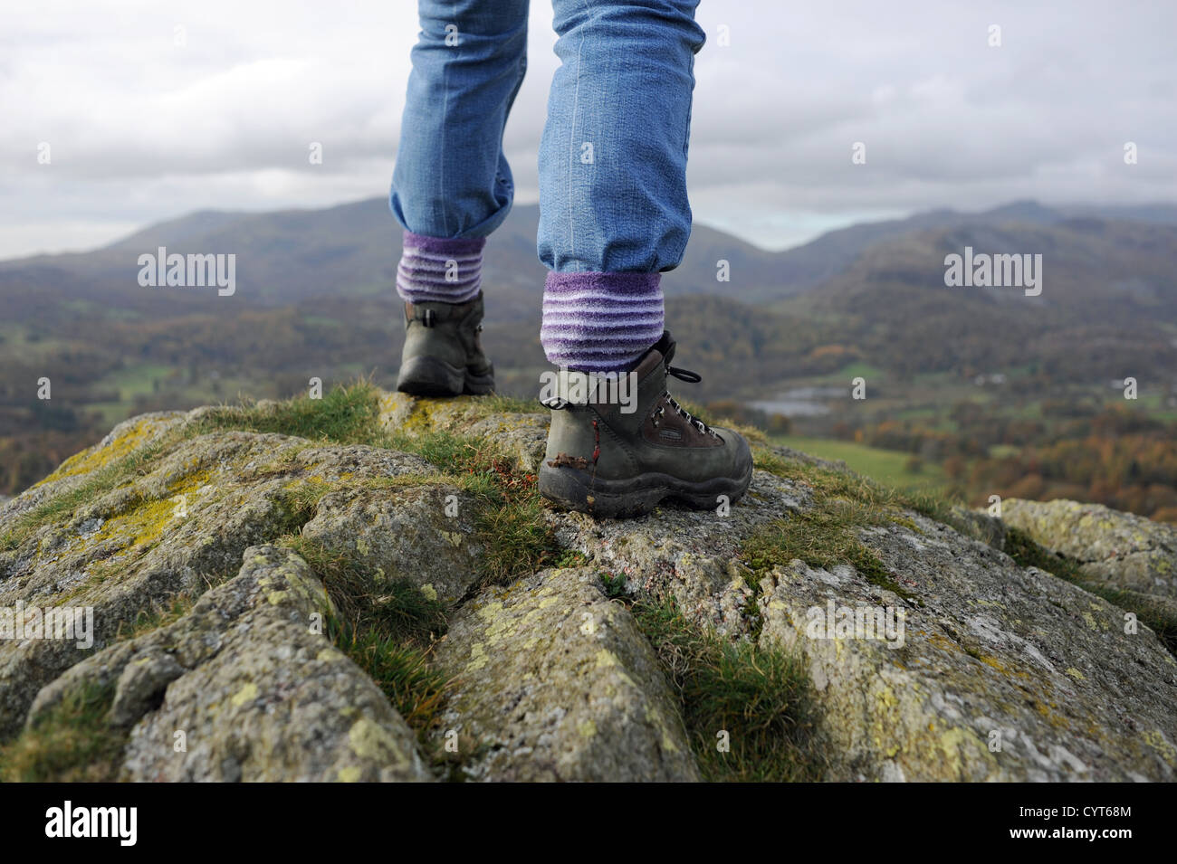 Viste intorno Loughrigg cadde vicino a Ambleside Lake District donna in scarponi la scalata verso la cima sui giorni di autunno Foto Stock