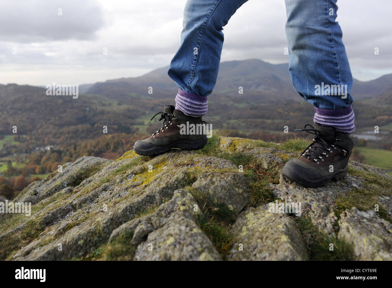 Viste intorno Loughrigg cadde vicino a Ambleside Lake District donna in scarponi la scalata verso la cima sui giorni di autunno Foto Stock