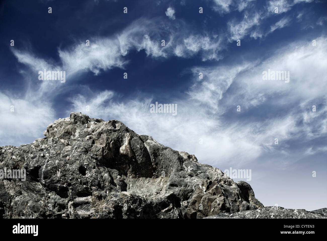 Falesia di montagna su nuvoloso cielo blu sullo sfondo Foto Stock
