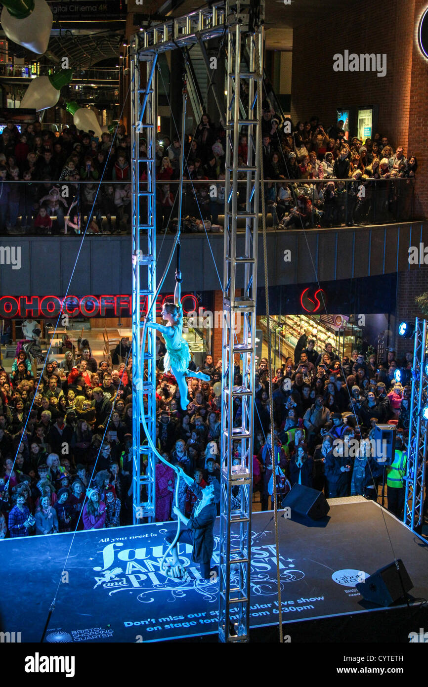 Una processione di Lost Boy tamburini e 150-strong processione della gioventù scuola di teatro danza bambini il loro modo dalle Gallerie di Cabot Circus. Bristol-basato Cirque Bijou con acrobazie, trampolieri e giocolieri intrattenere folle prima di Natale sono accese. Foto Stock