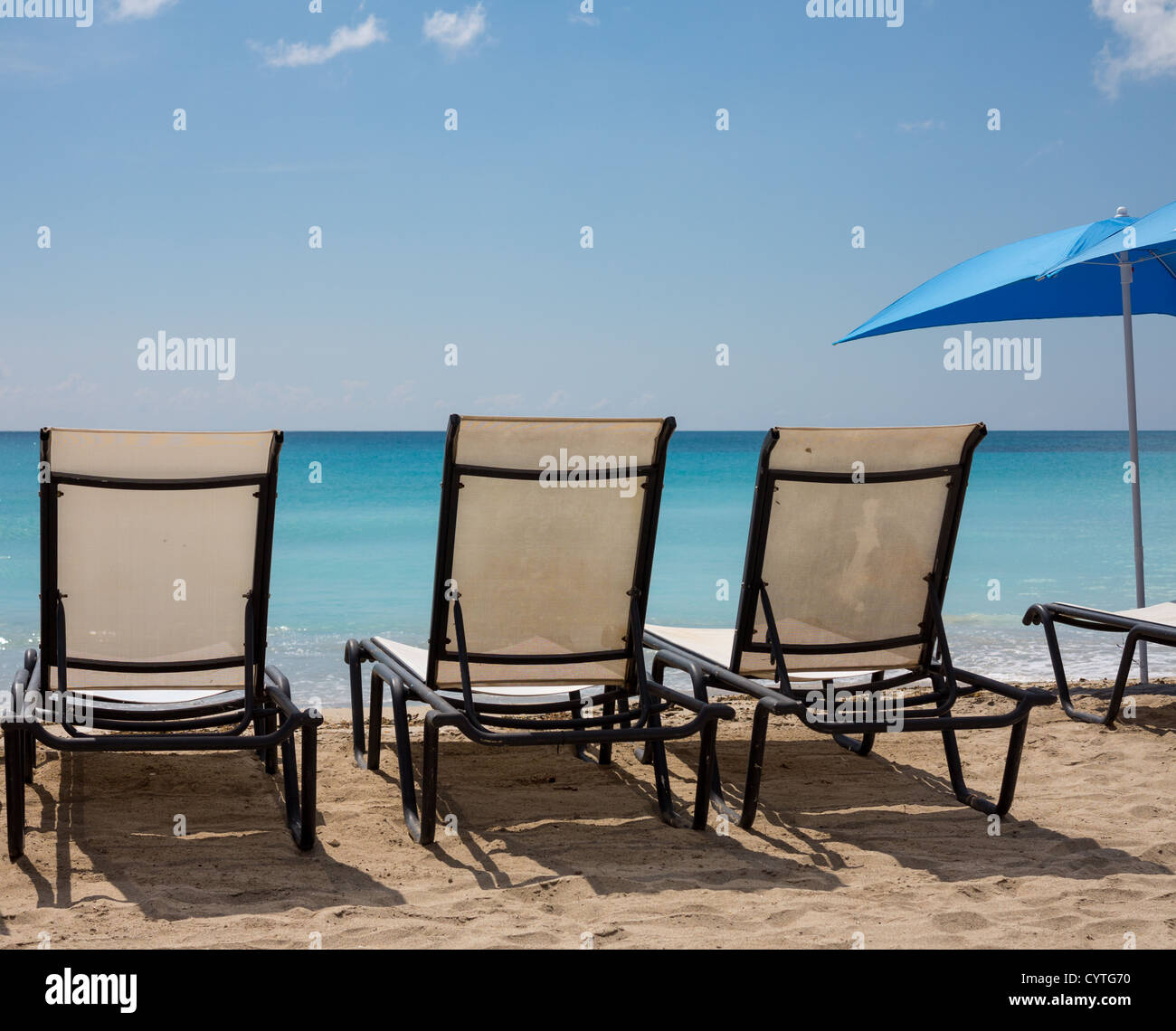 Tre black metal spiaggia sdraio e ombrellone in Orient Beach St Martin Foto Stock