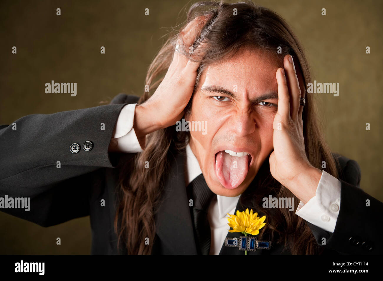 Uomo bello con la lingua di fuori in camicia formale con boutonniere Foto Stock