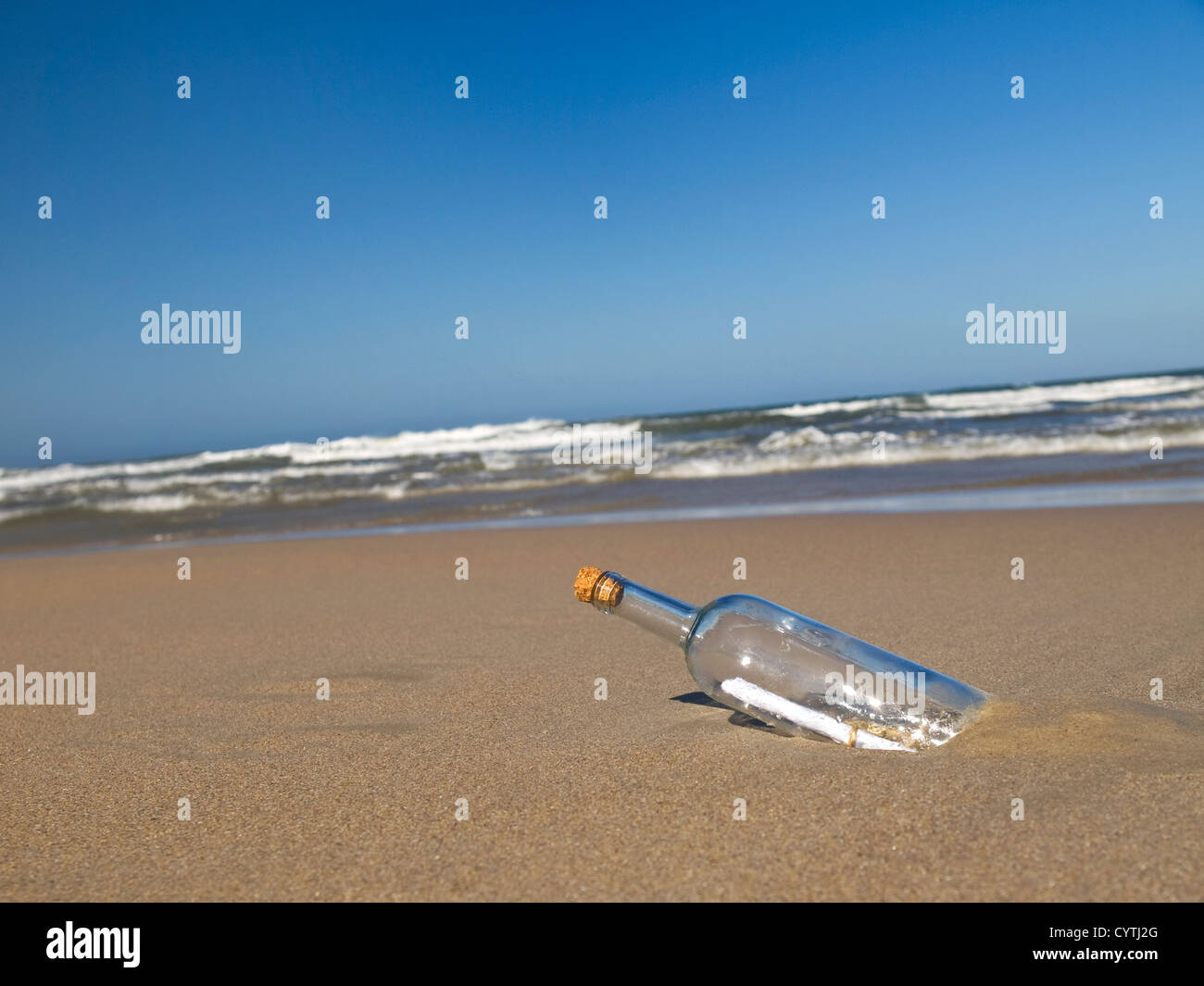 Un messaggio in una bottiglia abbandonata su una spiaggia. Foto Stock