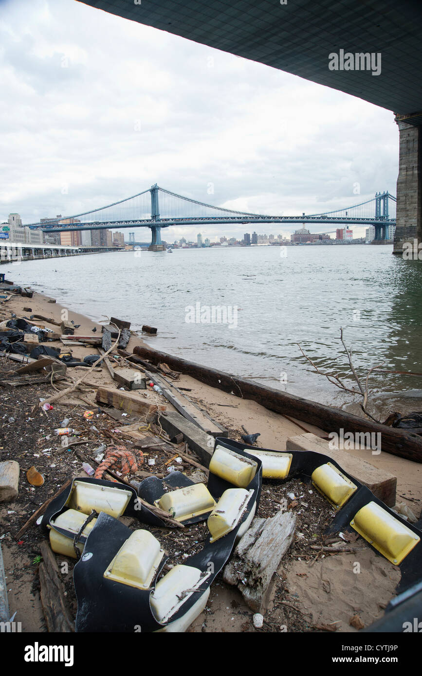 I detriti che è lavato fino sulla riva del fiume orientale a seguito della mareggiata da Superstorm Sandy sotto il ponte di Brooklyn Foto Stock