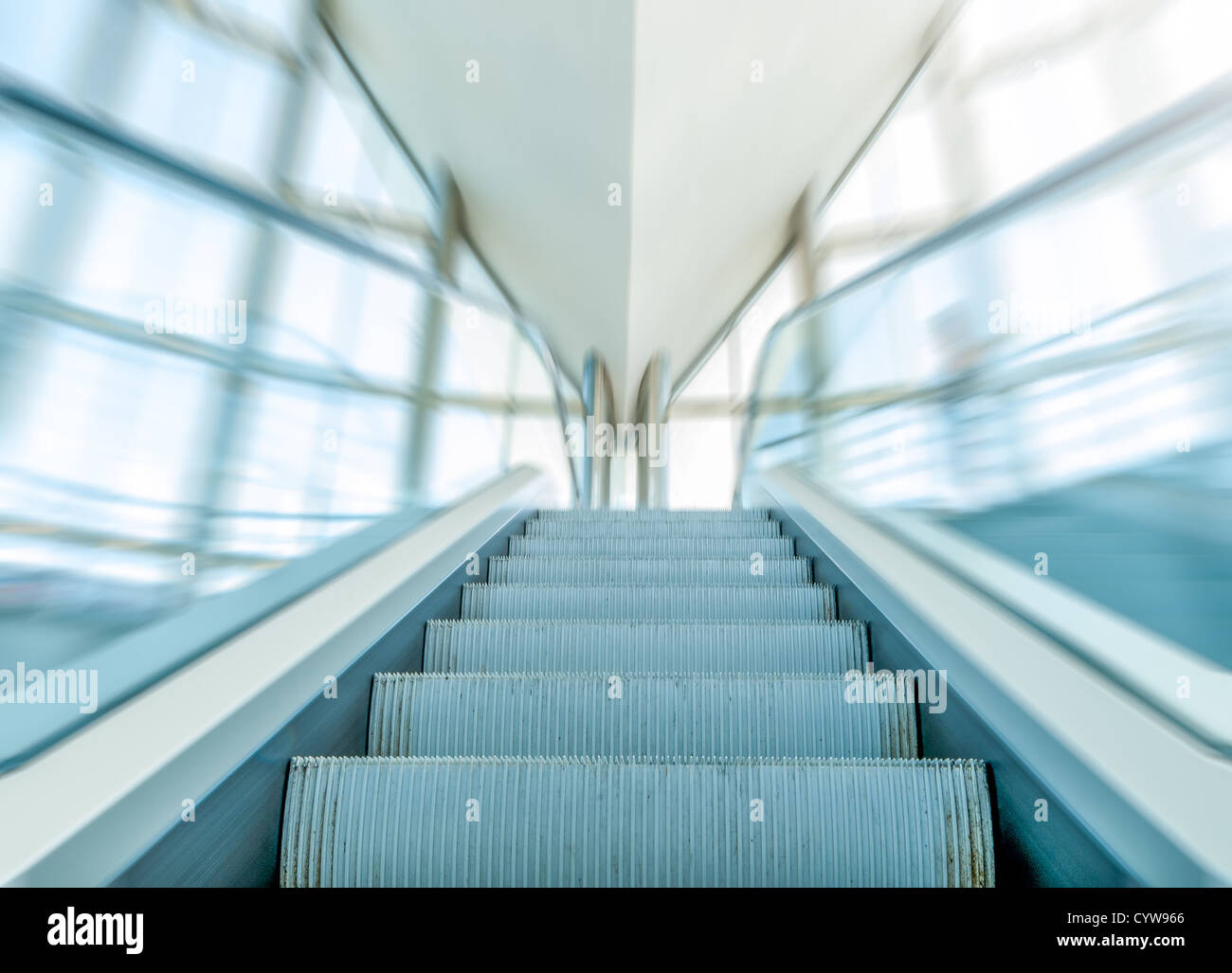 Vista ravvicinata della scala mobile o scala mobile all'interno del moderno centro business. Svuotare escalator con vetro blu corrimano in movimento. Foto Stock