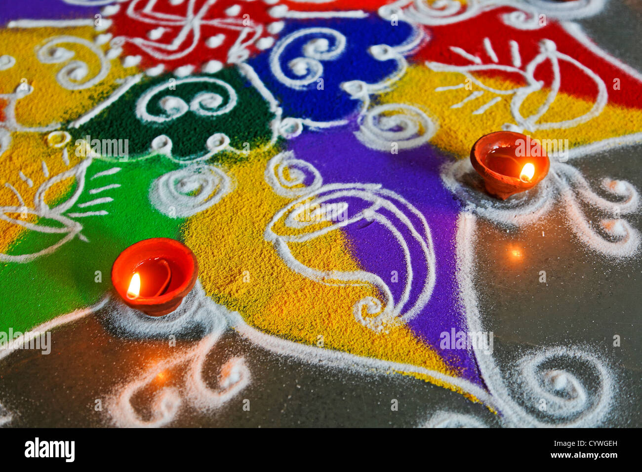 Rangoli a Divali abstract di colori e candele di forme e modelli di forma, disegnati a mano arte usando colori polveri di riso Foto Stock
