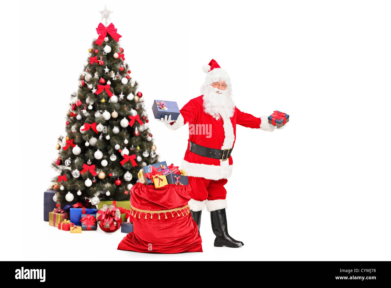 Babbo Natale regali da un sacco pieno di regali e albero di Natale decorato  in background Foto stock - Alamy