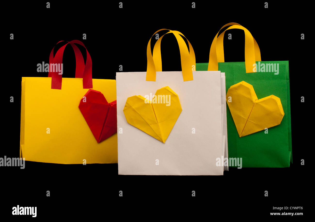 Verde, giallo e bianco borse per lo shopping con il cuore. Origami isolato Foto Stock