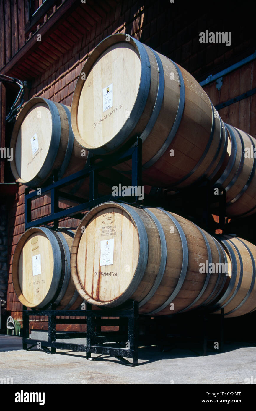 In legno barili di vino impilate lateralmente in fermentazione invecchiamento rack alla cantina, Oliver, BC, British Columbia, Canada Foto Stock