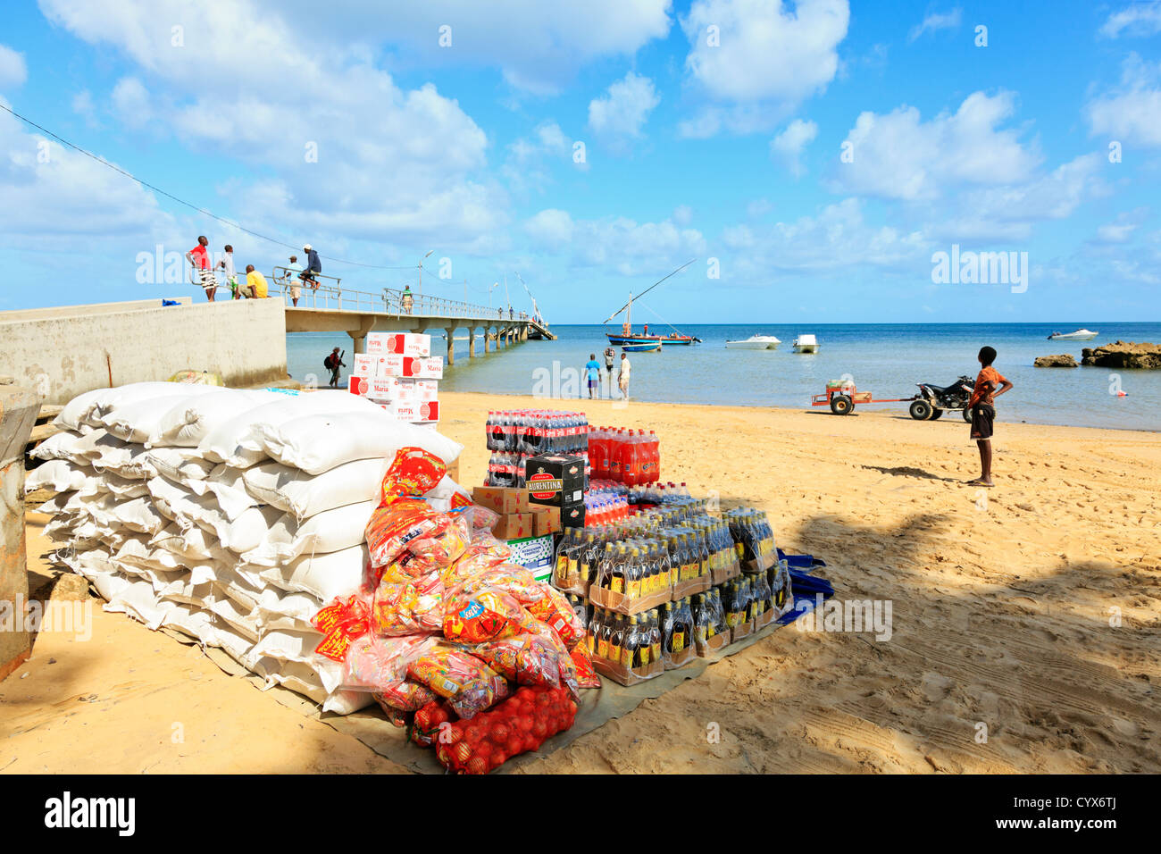 I materiali di consumo sono impilati sulla spiaggia dopo essere stato scaricato da un dhow ancorata nei fondali bassi. Isola di Inhaca Mozambico Foto Stock