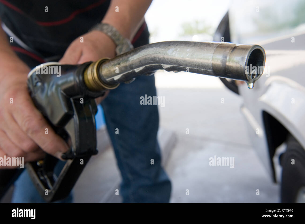 Una goccia di carburante diesel appesi ad un ugello carburante Foto Stock