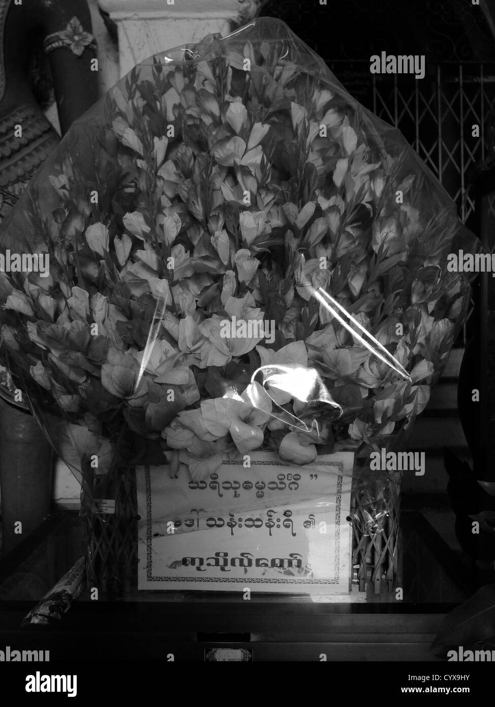 Fiori di seta sotto sellophane vengono disposte in un recipiente di argento come un offerta per il Buddha a tempio thatbyinnyu, MYANMAR Birmania Foto Stock