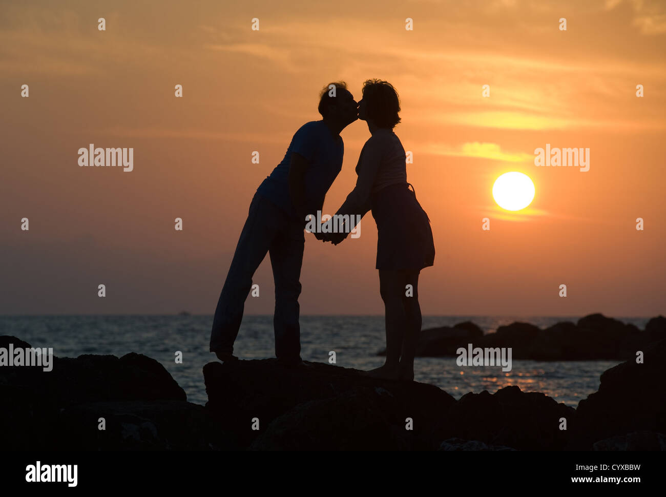 Un giovane dal tramonto su un molo kissing ogni altro Foto Stock