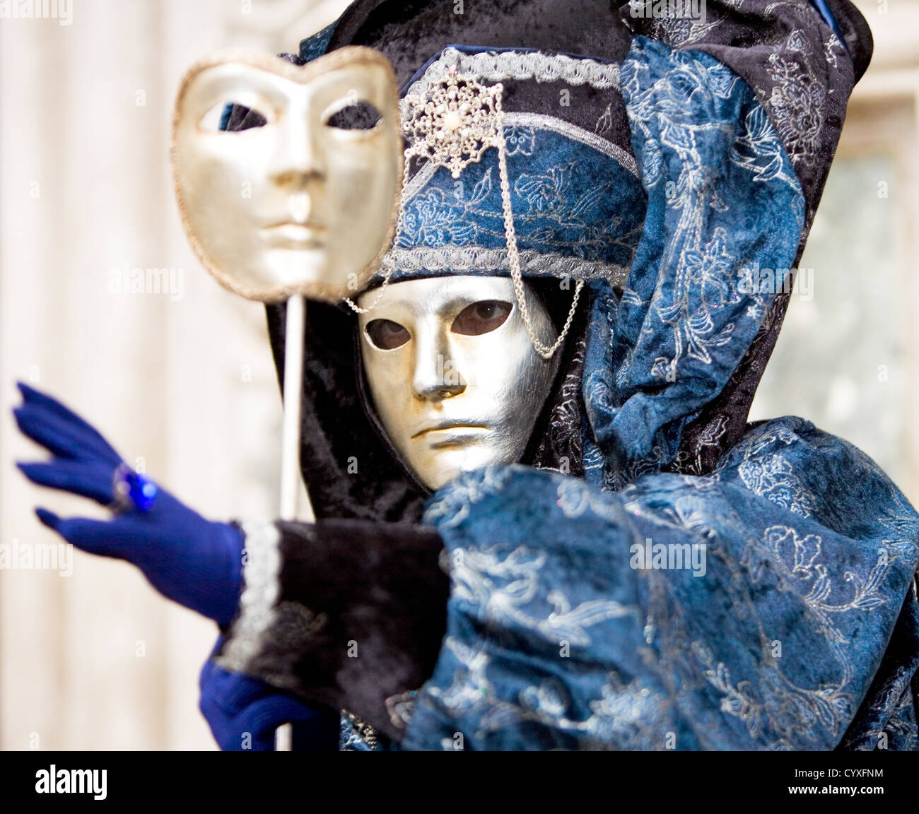 Un uomo in una maschera d'oro e blu costume di carnevale di Venezia Foto Stock