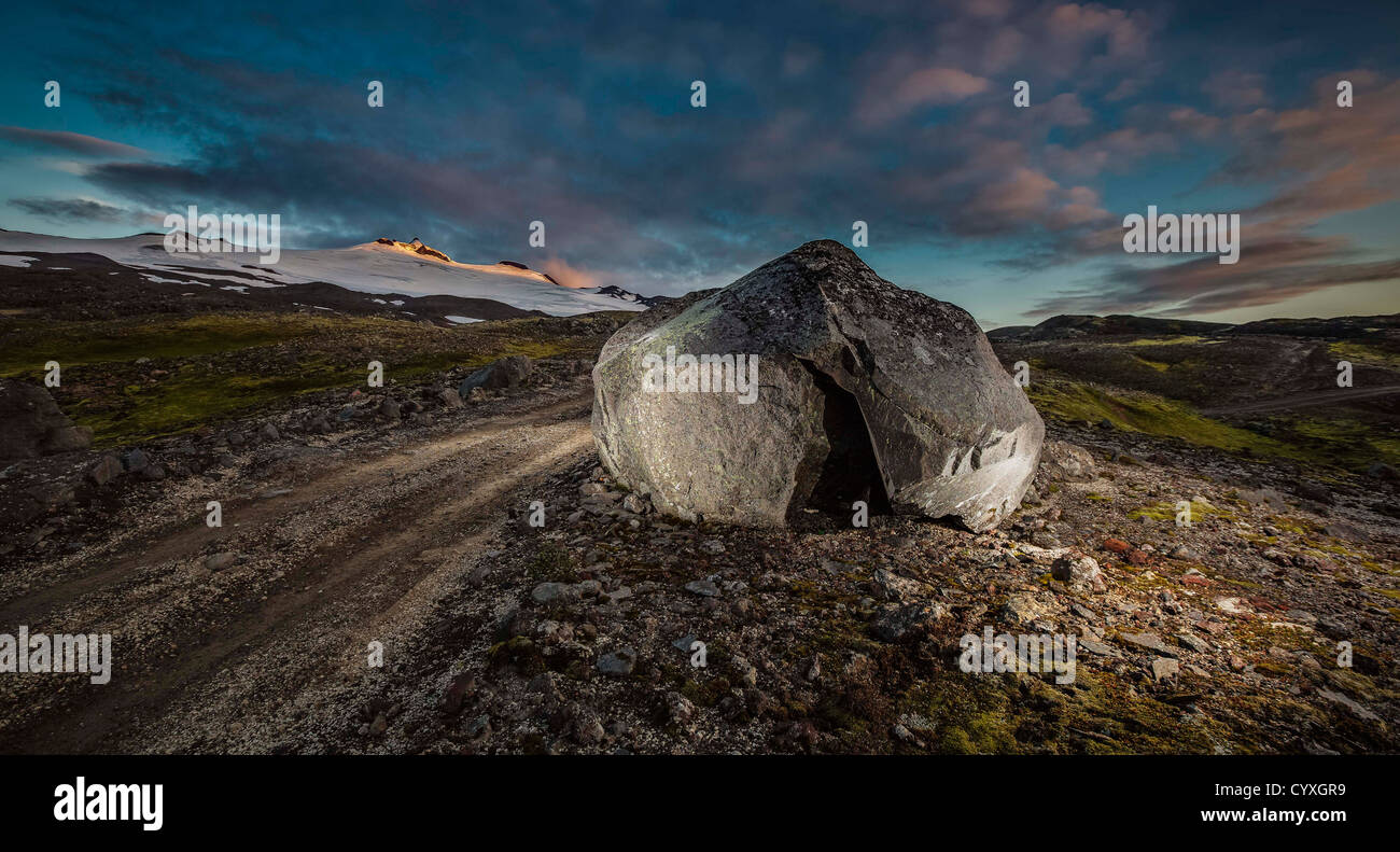 Grande roccia dalla strada di ghiaia vicino il versante nord del ghiacciaio Snaefellsjokull, Islanda Foto Stock