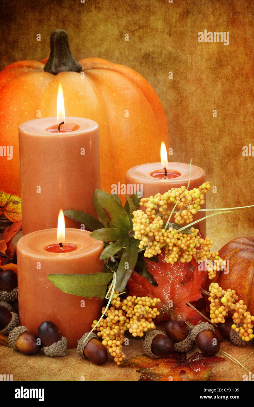 Foto immagine base di autunno ancora in vita di candele accese circondato da foglie colorate, zucche e ghiande. Foto Stock