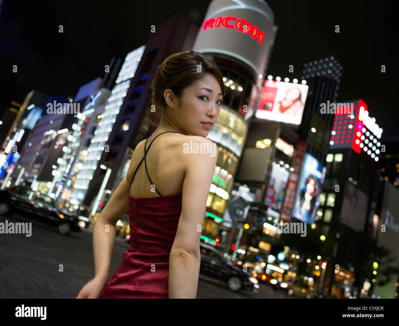 Bella giovane donna giapponese godendo la vita notturna e i negozi di Ginza ( Tokyo ) intorno al Ginza 4-chome crocevia. Foto Stock