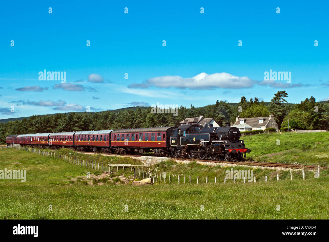 Conserve di ex British Railways 2-6-4T 80105 serbatoio vapore motore tira un treno alla stazione ferroviaria di Strathspey a nord di Boat of Garten Foto Stock