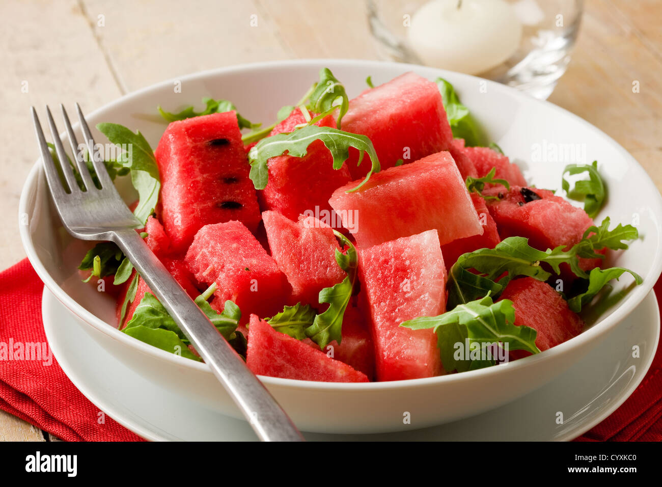 Foto di freschi e deliziosi anguria e insalata di rucola sul tavolo di legno Foto Stock