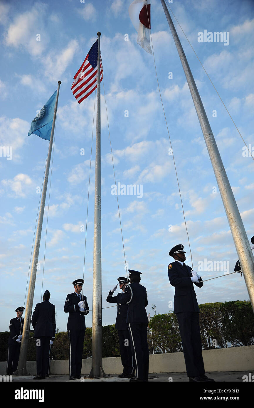 La Guardia d'Onore di Kadena e la Junior ROTC salutano le bandiere NATO, americane e giapponesi durante la cerimonia del Veteran's Day presso la base aerea di Kadena, onorando veterani e alleanze internazionali. Foto Stock