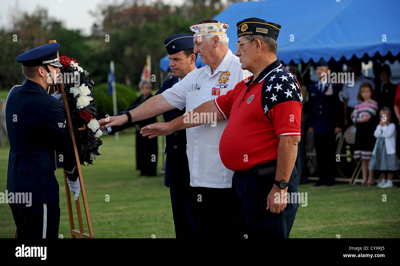 Leader dei veterani, tra cui Don Allen e Brig. Gen. Matt Molloy, mettete una mano sulla ghirlanda POW/mia della base aerea di Kadena durante le cerimonie del Veterans Day. Foto Stock