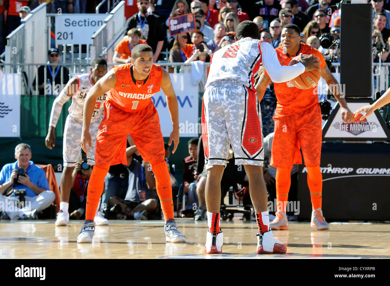 La Syracuse University Michael Carter-Williams difende la San Diego State University Xavier Tamigi durante il â€oeBattle sul Midwayâ€ gioco di basket a bordo del ponte di volo della USS Midway Museum, il lungo-servizio U.S. Navy carrier. Northrop Grumman pl Foto Stock