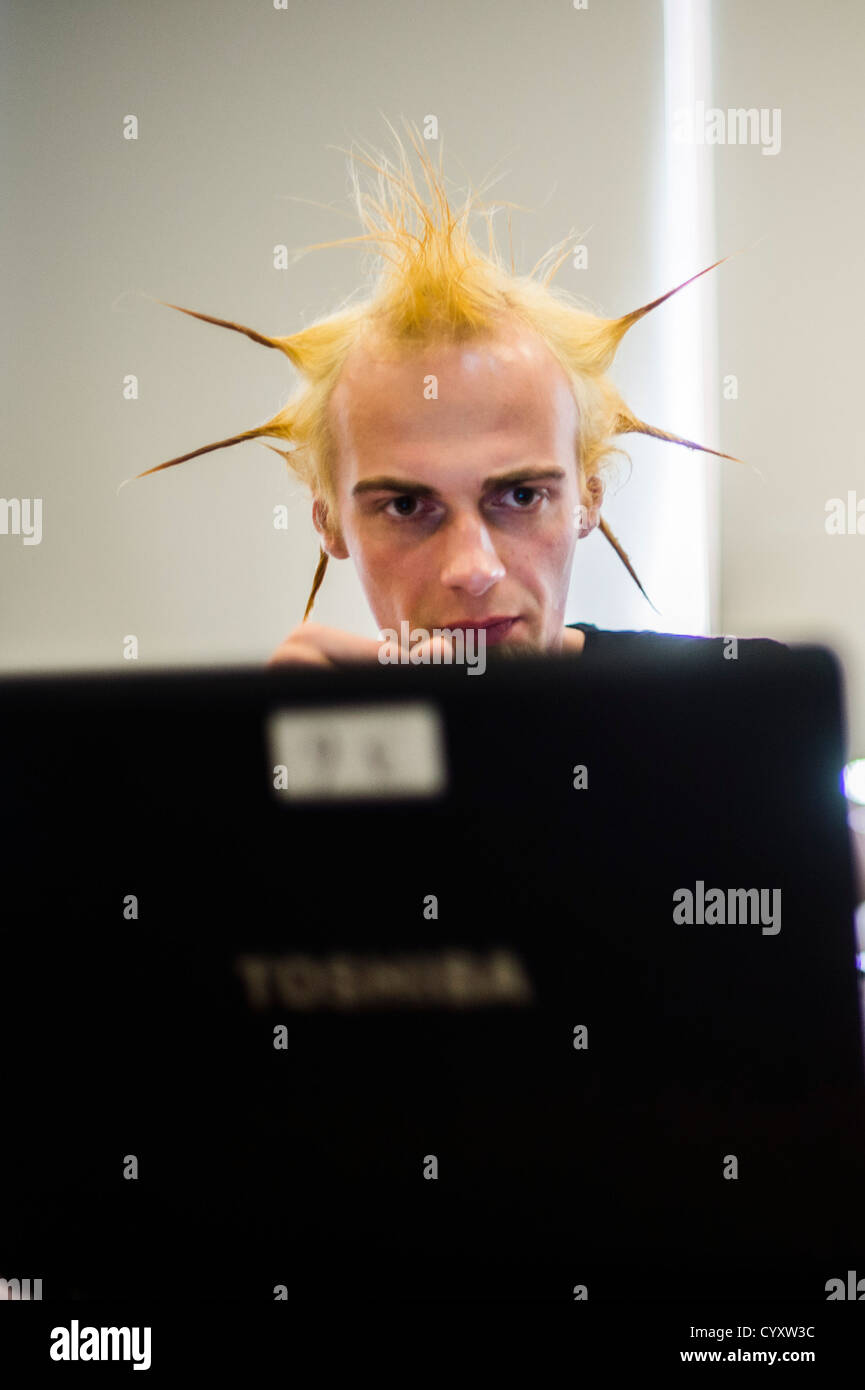 Un uomo con punky pungenti i capelli ad una ''TechnoCamp' inventore App workshop per 16-18 anni gli studenti a Coleg Ceredigion Aberystwyth Foto Stock