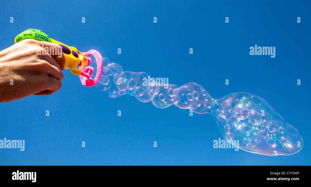 Bolle di sapone. Aria è il soffiaggio di aria attraverso un anello, coperto con acqua saponata. Realizzata con un giocattolo per bambini, una bolla di sapone macchina. Foto Stock