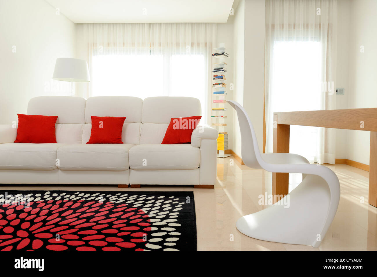 Soggiorno con divano bianco, tavolo da pranzo e Vitra Verner Panton Chair Foto Stock