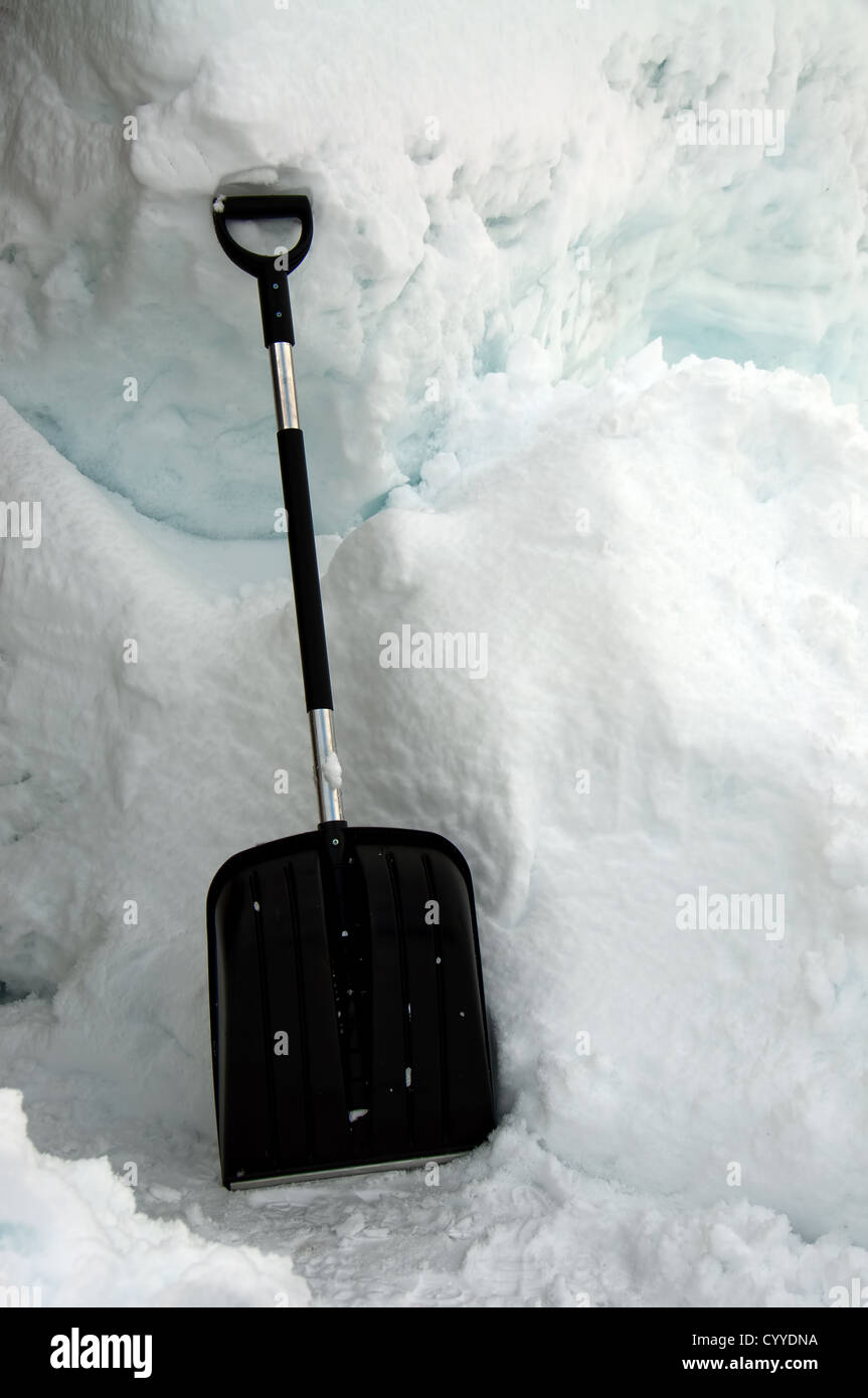 Un nero Pala da neve nella neve Foto Stock