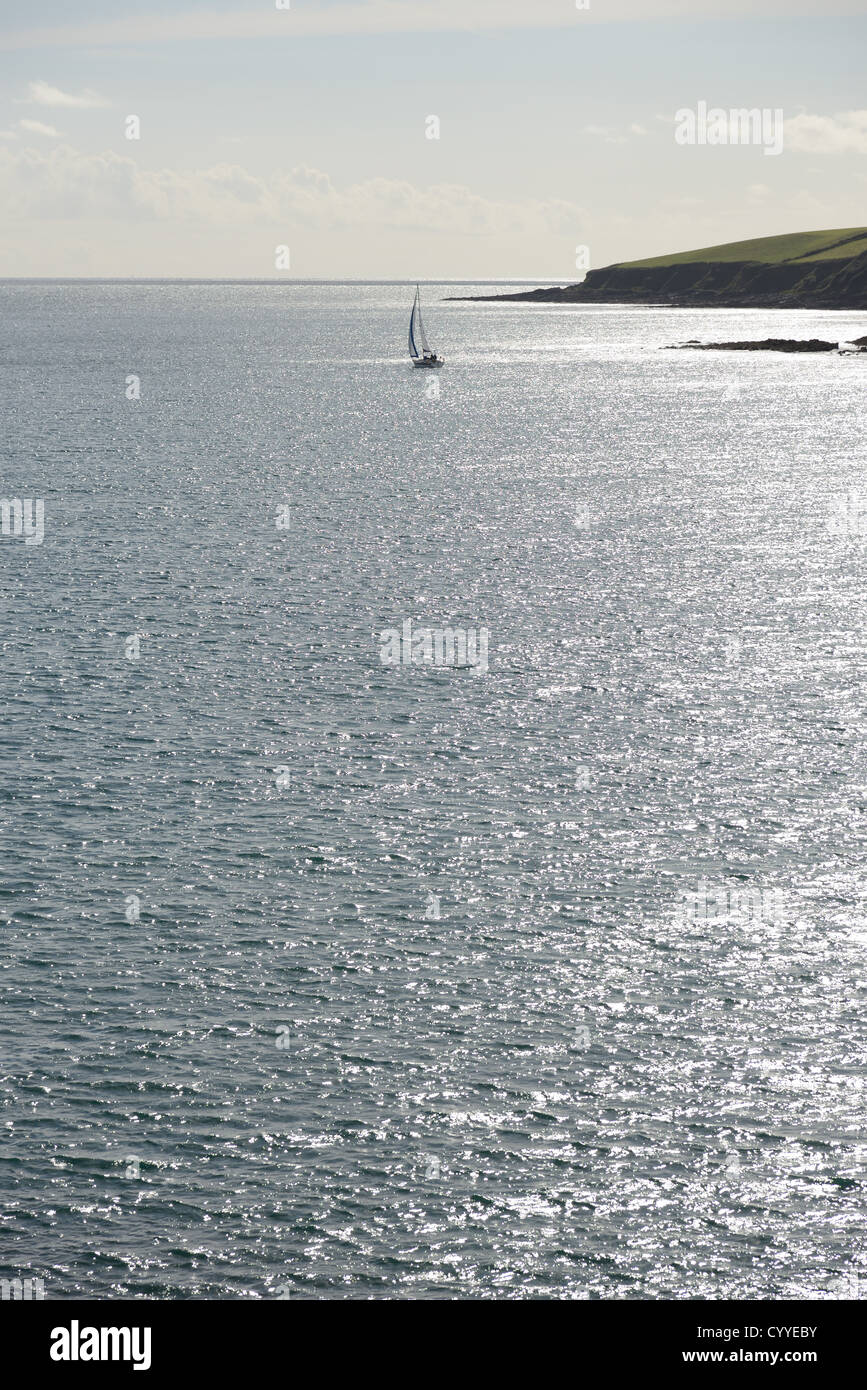 Barca vela lungo una costa pericolose Foto Stock