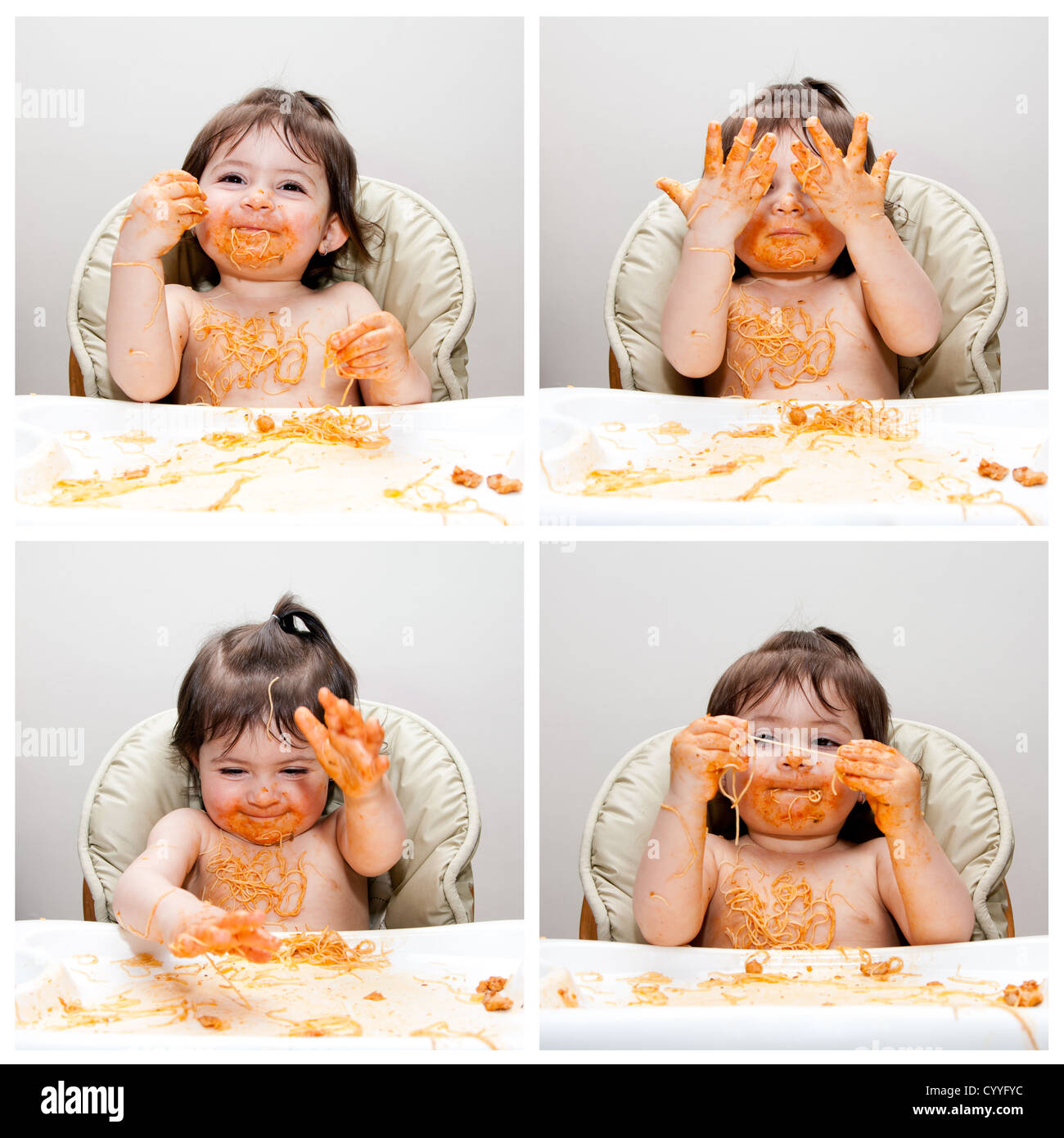 Happy baby divertirsi mangiando disordinati che mostra le mani coperte di spaghetti Angel Hair Pasta marinara rosso salsa di pomodoro. Foto Stock