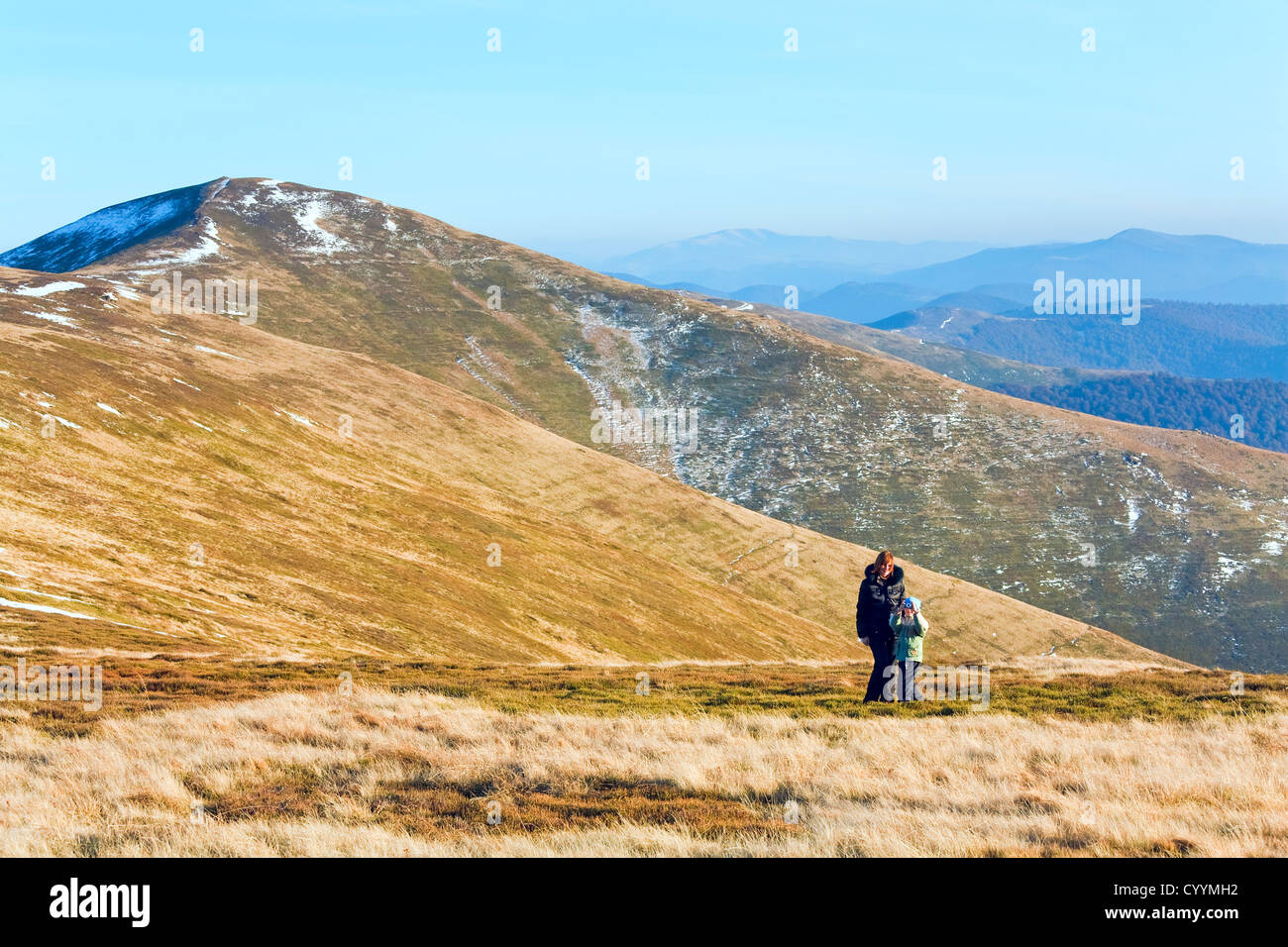 La famiglia (madre con Figlio) a piedi e fare foto in autunno montagna altopiano prima neve invernale Foto Stock