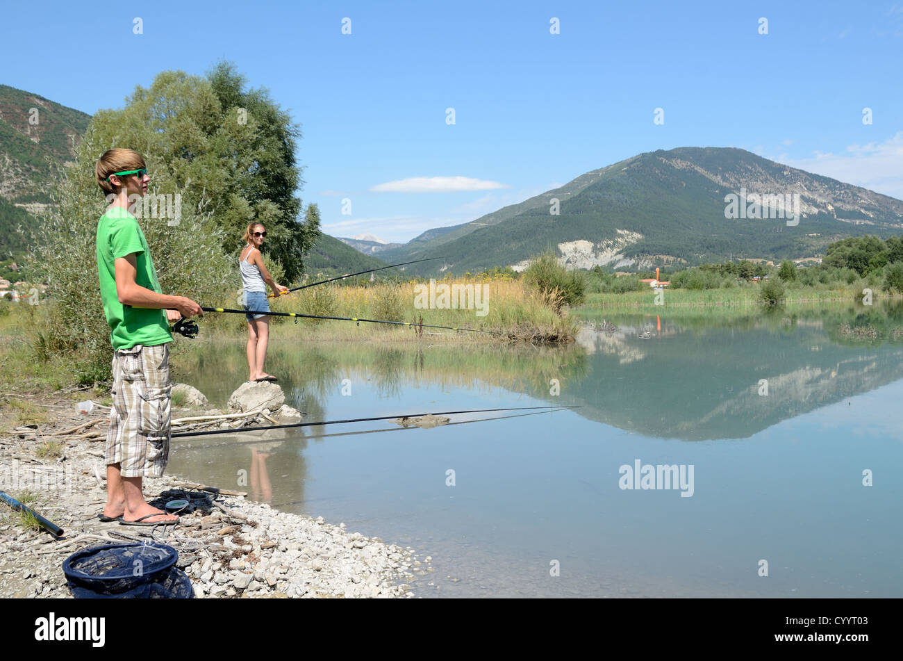 Ragazzo e ragazza o fratello e sorella grossa pesca nel lago di Castillon Saint-André-les-Alpes Alpes-de-Haute-Provence Francia Foto Stock