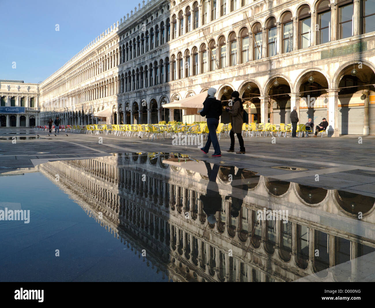 L'Italia, Venezia, Piazza San Marco allagata, con riflessioni di due ragazze, in sole al mattino Foto Stock