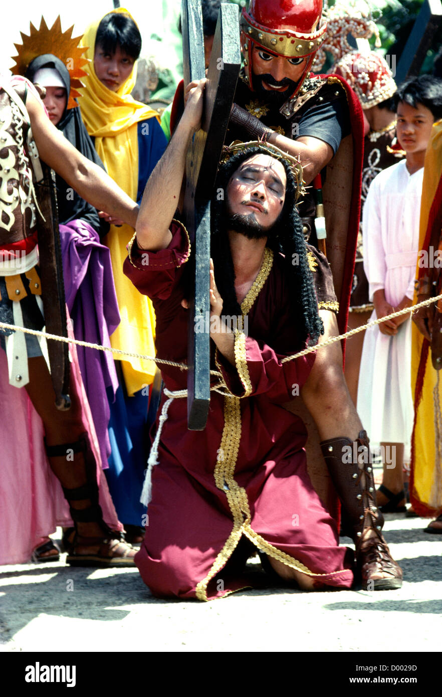 Filippine, Marinduque Isola, Boac, adoratore vestito come Cristo che porta cross durante la Moriones Festival. Foto Stock