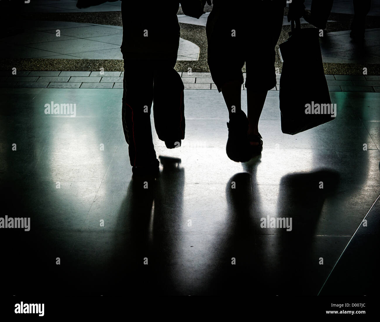Silhouette di acquirenti' piedi a piedi da un centro commerciale di Kuala Lumpar, Malaysia Foto Stock