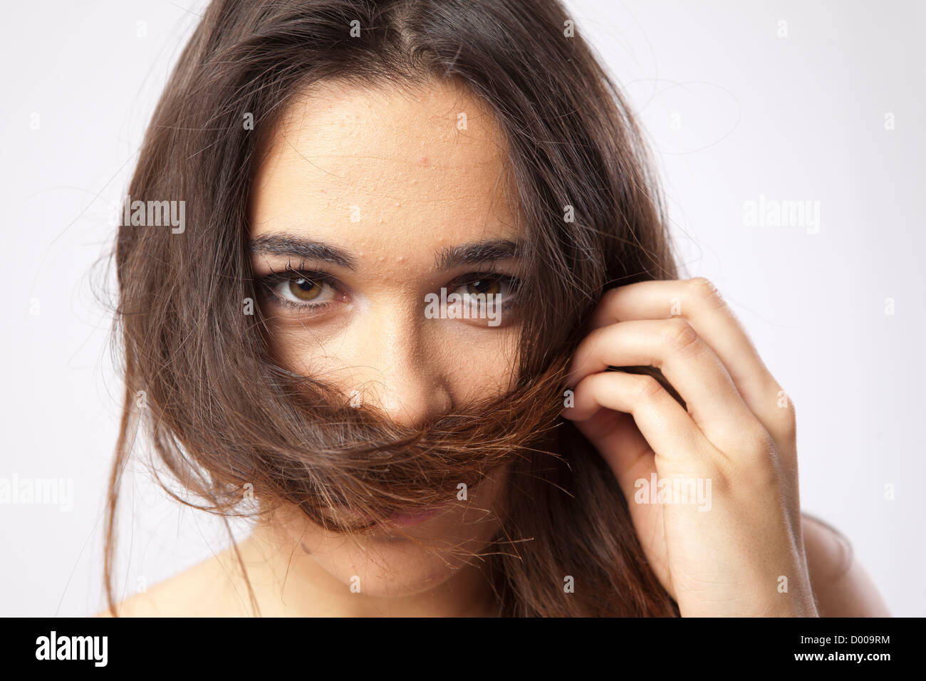 Real giovane e bella ragazza che gioca con i suoi capelli Foto Stock