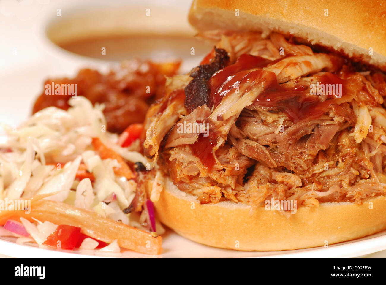 Grigliata di carne di maiale tirato in sandwich con coleslaw e fagioli al forno Foto Stock